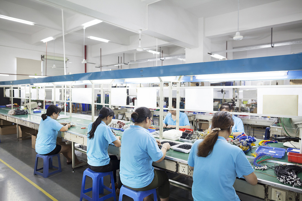 Traballadores dunha fábrica de produtos electrónicos en Dongguan, China